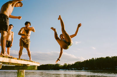 Low angle view of woman jumping in lake