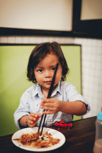 Portrait of cute girl eating food at home