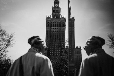 Reflection of people on building against sky