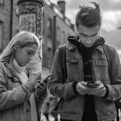 Full length of young man using mobile phone in city