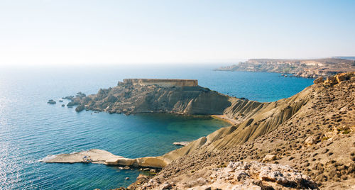 Scenic view of sea by rock formations against sky