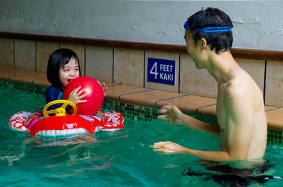 Man with daughter in swimming pool