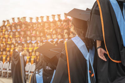 Women wearing mortarboard against sky