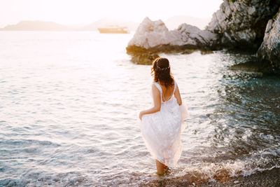 Rear view of woman standing in sea