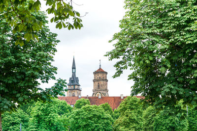 Low angle view of trees and buildings against sky