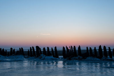 Scenic view of sea against clear sky at sunset