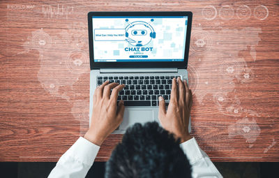 Rear view of man using laptop on table