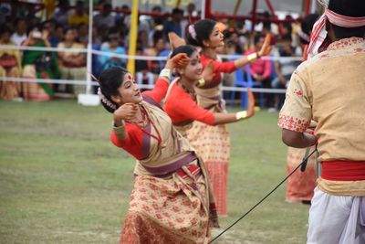 Group of people dancing bihy outdoors in assam. 