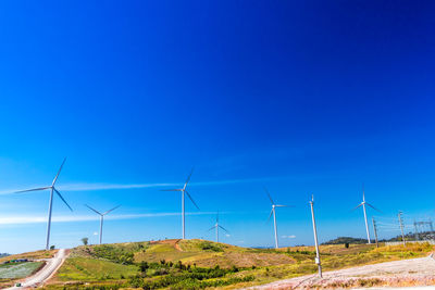 Wind turbines on land against sky