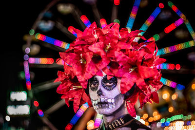 Portrait of woman with pink flowers at night