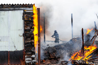 Panoramic view of man standing by fire against sky