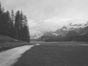 Road by mountains against sky