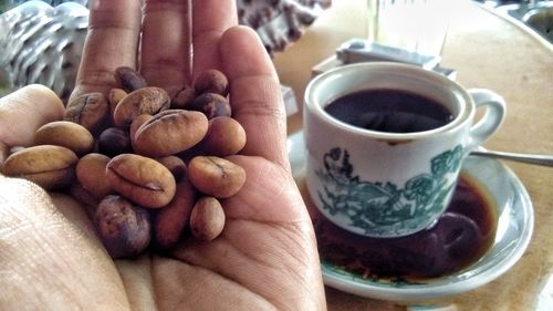 Close-up of hand holding coffee cup