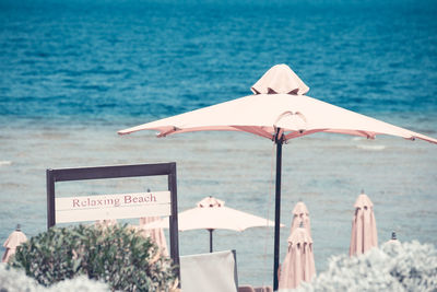 Deck chairs on beach against sea