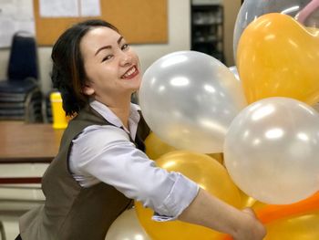 Portrait of a smiling young woman with balloons