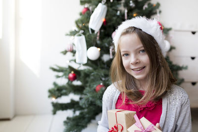 Girl against christmas tree at home