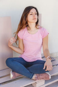 Young women in pink t-shirt and touching her long hair