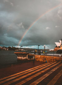 Rainbow over city against sky