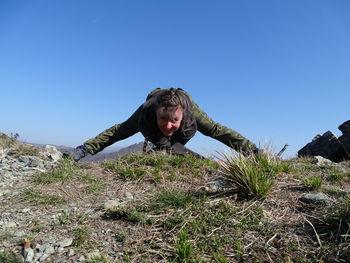 Man with arms raised against clear sky