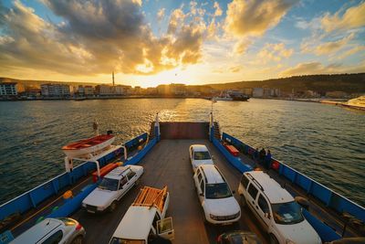 Boats in sea at sunset