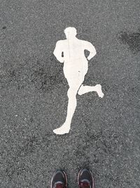 Low section of man standing on road