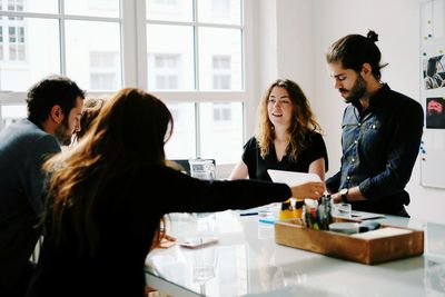 Colleagues discussing at desk in office