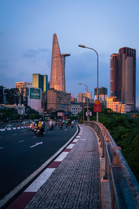 Street amidst buildings against sky at dusk