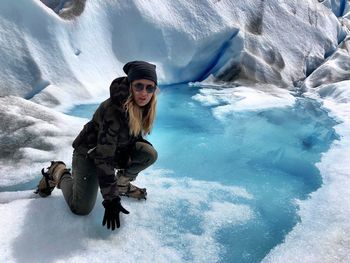 Portrait of mature woman kneeling at glacier 