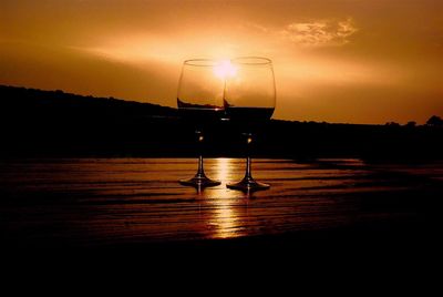 Close-up of beer on table against sunset