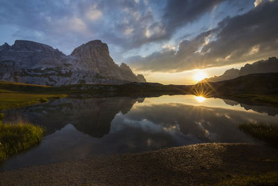 Scenic view of lake and snowcapped mountains against sky during sunset