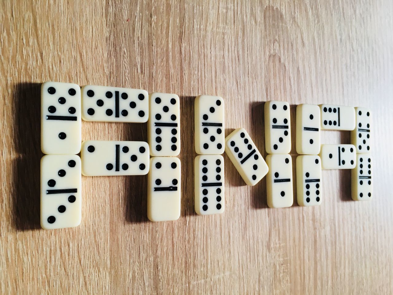 DIRECTLY ABOVE SHOT OF PIANO KEYS ON TABLE AGAINST WOODEN WALL