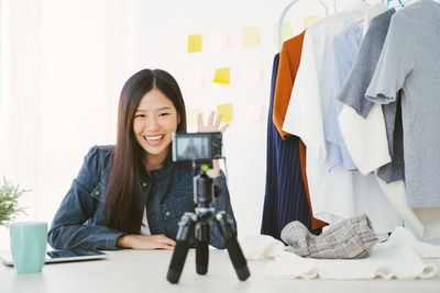 Camera filming smiling fashion designer at studio