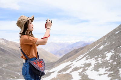 Full length of man standing on mountain against sky