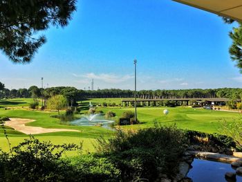 Scenic view of golf course against clear sky