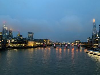 Illuminated buildings in city at waterfront