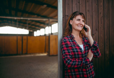 Smiling young woman using mobile phone