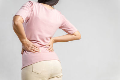 Rear view of woman touching white background