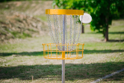 Close-up of yellow container on field