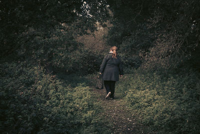 Rear view of woman walking in forest