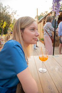 Woman sitting at a table in summer cafe with drank, genk, belgium, june 16, 2023
