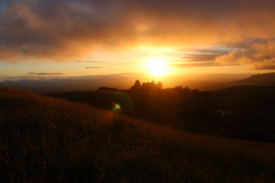 Scenic view of field against sky during sunset