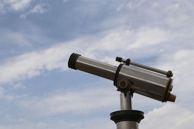 Low angle view of telescope against cloudy sky