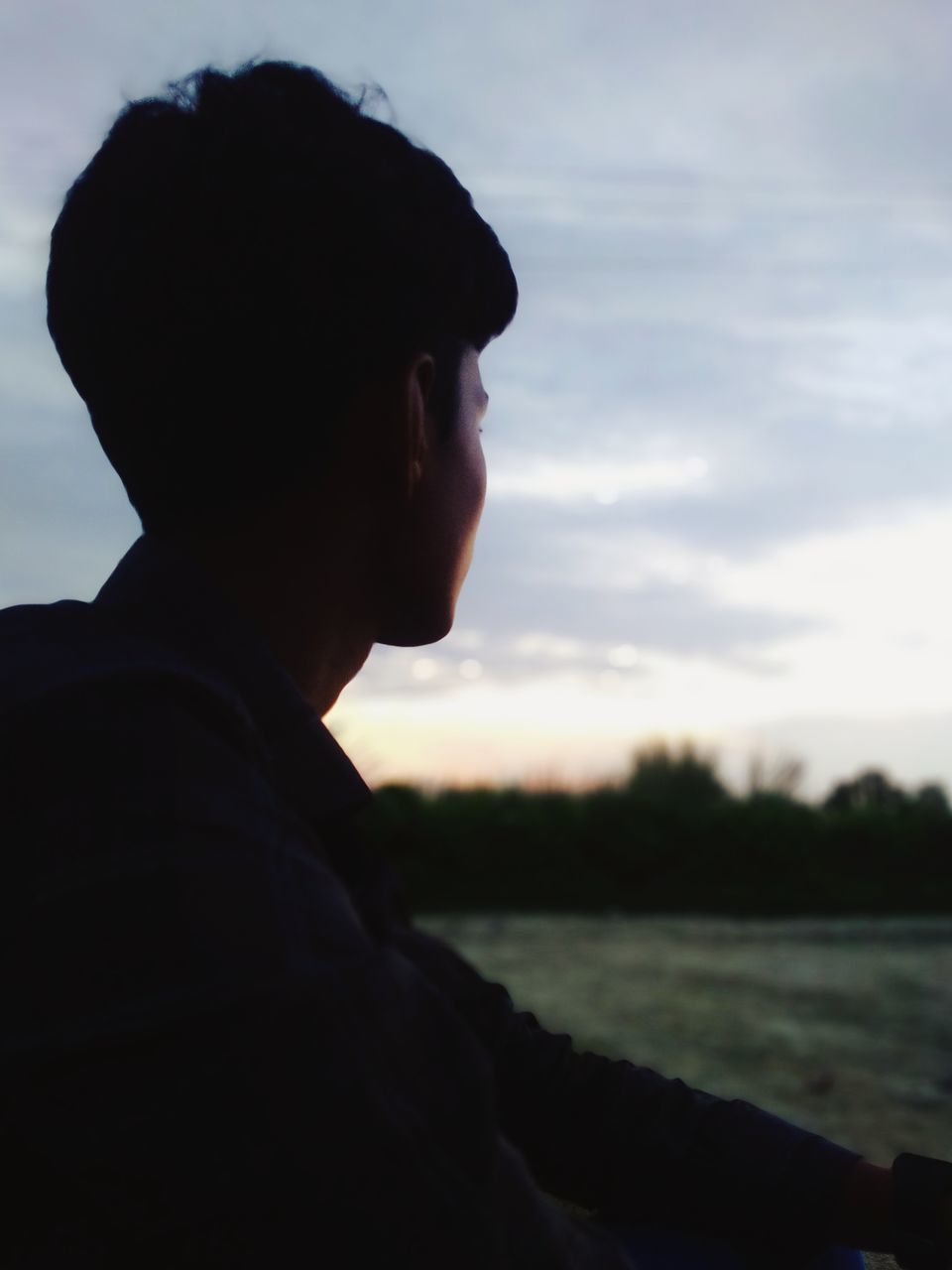 one person, sky, side view, adult, silhouette, cloud, blue, nature, headshot, black, portrait, contemplation, looking, men, profile view, sunset, outdoors, looking away, young adult, dusk, focus on foreground, sadness, lifestyles, leisure activity, person, water, light, day, tranquility