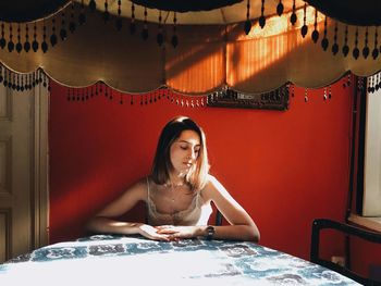 Portrait of young woman sitting on table