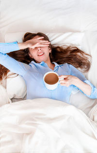 High angle view of woman lying on bed