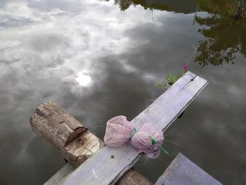 High angle view of wooden table by lake against sky