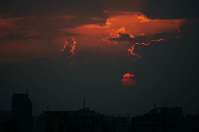 High section of silhouette buildings against scenic sky