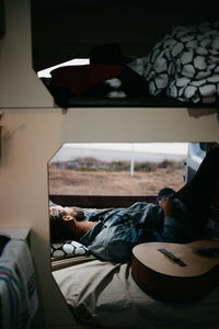 Midsection of man resting on bed at home