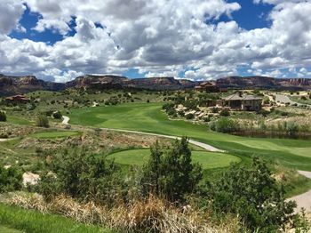 Scenic view of golf course against sky