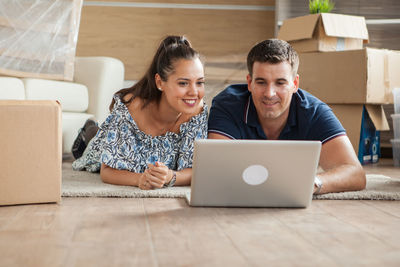 Young woman using laptop while sitting on table